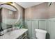 Charming powder room with marble counter, decorative wallpaper, and round mirror at 3 Queen St # 315, Charleston, SC 29401
