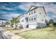 A row of well-maintained townhomes with white siding, complemented by lush green lawns and swaying palm trees at 307 Lanyard St, Johns Island, SC 29455