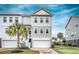 Inviting two-story townhome with a ground-level garage and a charming palm tree in the front yard at 307 Lanyard St, Johns Island, SC 29455