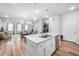 Bright, open kitchen flows to living space, featuring white cabinets, countertops and hardwood floors at 307 Lanyard St, Johns Island, SC 29455