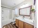 A bright bathroom with a shower-tub, a vanity with light-colored cabinets, and a large mirror at 308 Burton Ave, Summerville, SC 29485