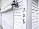 Close-up of the house number '308' next to a white garage door with an outdoor lantern at 308 Burton Ave, Summerville, SC 29485