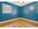Blue bedroom with hardwood floors, a window, and essential electrical outlets at 3143 Bonanza Rd, Charleston, SC 29414