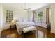 Bright bedroom with wood floors, ceiling fan, a bed with patterned linens, and windows providing natural light at 3168 Stanyarne Dr, Charleston, SC 29414