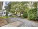 Cozy backyard features a stone patio, mature trees, a grill, and a small playset, perfect for outdoor enjoyment at 3302 Porchview Pl, Johns Island, SC 29455