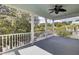 Spacious covered porch with a ceiling fan and white railing, overlooking a tranquil, tree-lined street at 3302 Porchview Pl, Johns Island, SC 29455