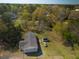 Aerial view of a home, shed, and vehicle amid a mix of trees and green spaces at 389 Maggie Rd, Mount Pleasant, SC 29464