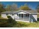 Charming single-story home featuring a gray exterior and a welcoming front porch with white railing at 389 Maggie Rd, Mount Pleasant, SC 29464