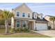 Charming two-story home featuring a stone and vinyl facade, attached garage, and a well-manicured lawn at 470 Gianna Ln, Goose Creek, SC 29445
