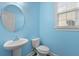 Powder room features pedestal sink, round mirror, and toilet with a window providing natural light at 470 Gianna Ln, Goose Creek, SC 29445