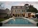 Luxury backyard with a large pool, outdoor kitchen, lounge chairs, lush lawn, and beautiful stone facade at 478 Huger St, Charleston, SC 29403