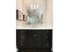 Elegant bathroom vanity with a black cabinet, white countertop, decorative mirror, and contemporary lighting at 478 Huger St, Charleston, SC 29403