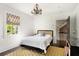 Cozy bedroom with a queen bed, colorful polka dot wall, and an elegant chandelier and natural light from the window at 478 Huger St, Charleston, SC 29403