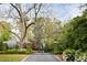 Elegant gated entrance with lush landscaping and stately trees along a paved driveway leading to the property at 478 Huger St, Charleston, SC 29403