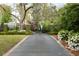 Long driveway leading to gated property; lush landscaping of manicured lawns, shrubs, mature trees and blooming ground cover at 478 Huger St, Charleston, SC 29403