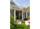 Home featuring a stone front with black door and a balcony, complemented by manicured greenery at 478 Huger St, Charleston, SC 29403