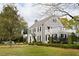 Charming stone home with dark shutters, complemented by a lush green lawn and mature trees, offering classic elegance at 478 Huger St, Charleston, SC 29403