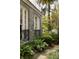 Side exterior view showcasing stonework, a wrought iron fence, and verdant landscaping at 478 Huger St, Charleston, SC 29403