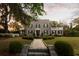 Charming stone home featuring manicured lawn, mature trees and greenery, and a welcoming walkway at 478 Huger St, Charleston, SC 29403