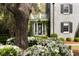Charming stone residence with lush white flowering plants, mature trees, and architectural details, offering a serene ambiance at 478 Huger St, Charleston, SC 29403