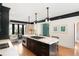 Well-lit kitchen features a marble island with a gas stove, dark cabinetry, and hardwood floors at 478 Huger St, Charleston, SC 29403