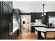 Modern kitchen with black cabinetry, stainless steel appliances, a marble countertop island, and herringbone wood floors at 478 Huger St, Charleston, SC 29403
