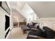 Comfortable attic living room with black sofa, ottoman, and natural light streaming through the windows at 478 Huger St, Charleston, SC 29403