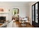 Stylish living room showcasing a fireplace, dining area, herringbone floors, and natural light through a black-framed door at 478 Huger St, Charleston, SC 29403