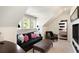 Cozy attic living room featuring a black sofa, leather ottoman, and bright windows at 478 Huger St, Charleston, SC 29403