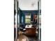 Stylish office with blue walls, a wooden desk, a black leather chair, and an interesting portrait at 478 Huger St, Charleston, SC 29403