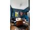 Stylish office with blue walls, a wooden desk, a black leather chair, and an interesting portrait at 478 Huger St, Charleston, SC 29403