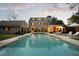 Elegant pool and patio area with inviting lounge chairs in backyard with lush landscaping and stone house at 478 Huger St, Charleston, SC 29403