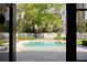 Beautiful backyard pool with a clean design and a surrounding stone patio, as seen through an open doorway at 478 Huger St, Charleston, SC 29403
