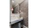 Chic powder room with zebra wallpaper, stylish sconces, and a unique sink and mirror combination at 478 Huger St, Charleston, SC 29403