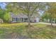 Well-kept home with a green lawn, mature trees, and an attached one-car garage, presenting a welcoming curb appeal at 5033 Thornton Dr, Summerville, SC 29485