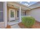Covered front porch featuring a glass door, white columns, and manicured landscaping for a welcoming entrance at 5033 Thornton Dr, Summerville, SC 29485