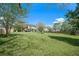 Expansive backyard with lush green grass, mature trees, a fire pit, and a screened-in porch, perfect for outdoor living at 529 Beverly Dr, Summerville, SC 29485