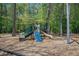 Playground with slide, climbing area, and swing set in a wooded community setting at 529 Beverly Dr, Summerville, SC 29485