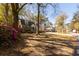 Charming brick home with an attached garage, surrounded by mature trees and vibrant azaleas along a quiet street at 643 Edmonds Dr, Charleston, SC 29412