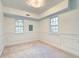 A spacious bedroom features neutral carpet, trim, and natural light from the two windows at 6464 St Anthony Dr, Hollywood, SC 29449