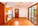 Open dining room with hardwood floors, a glass door to the outside, and a classic light fixture at 6464 St Anthony Dr, Hollywood, SC 29449