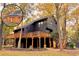 Stunning dark home exterior with a large wraparound deck and complementing natural wood staircase at 6464 St Anthony Dr, Hollywood, SC 29449