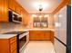 Bright eat-in kitchen with stainless appliances, tile backsplash and floors, and classic wood cabinets at 6464 St Anthony Dr, Hollywood, SC 29449