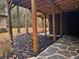 Covered patio area featuring stone flooring and black mulch landscaping at 6464 St Anthony Dr, Hollywood, SC 29449