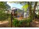 View of the backyard featuring a screened in deck, brick facade and lush landscaping around a picket fence at 683 Edmonds Dr, Charleston, SC 29412