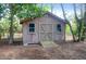 Charming wooden shed with double doors, ideal for storage or a workshop, set in a green backyard at 683 Edmonds Dr, Charleston, SC 29412