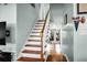 A staircase with wooden treads, white risers and bannister and a view to an exterior door at 683 Edmonds Dr, Charleston, SC 29412