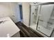 Bright bathroom with white cabinets and countertops, a glass-enclosed shower, and dark wood laminate flooring at 700 Pisces Ln, Summerville, SC 29486