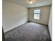 Cozy bedroom with soft carpeting and a window offering a glimpse of the outside neighborhood at 700 Pisces Ln, Summerville, SC 29486