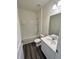 A well-lit bathroom with a shower-tub combo, modern vanity, and luxury vinyl plank flooring at 707 Pisces Ln, Summerville, SC 29486